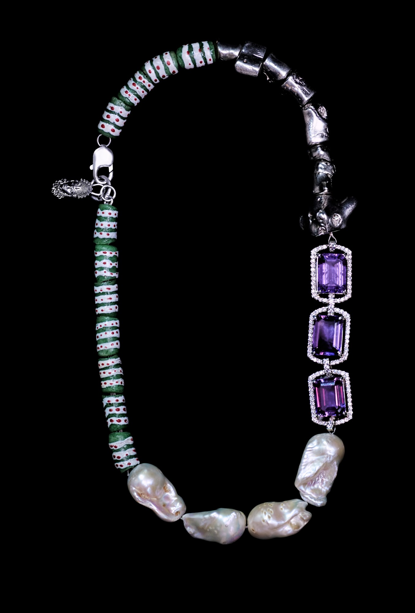 a beaded pearl and amethyst necklace against a black background