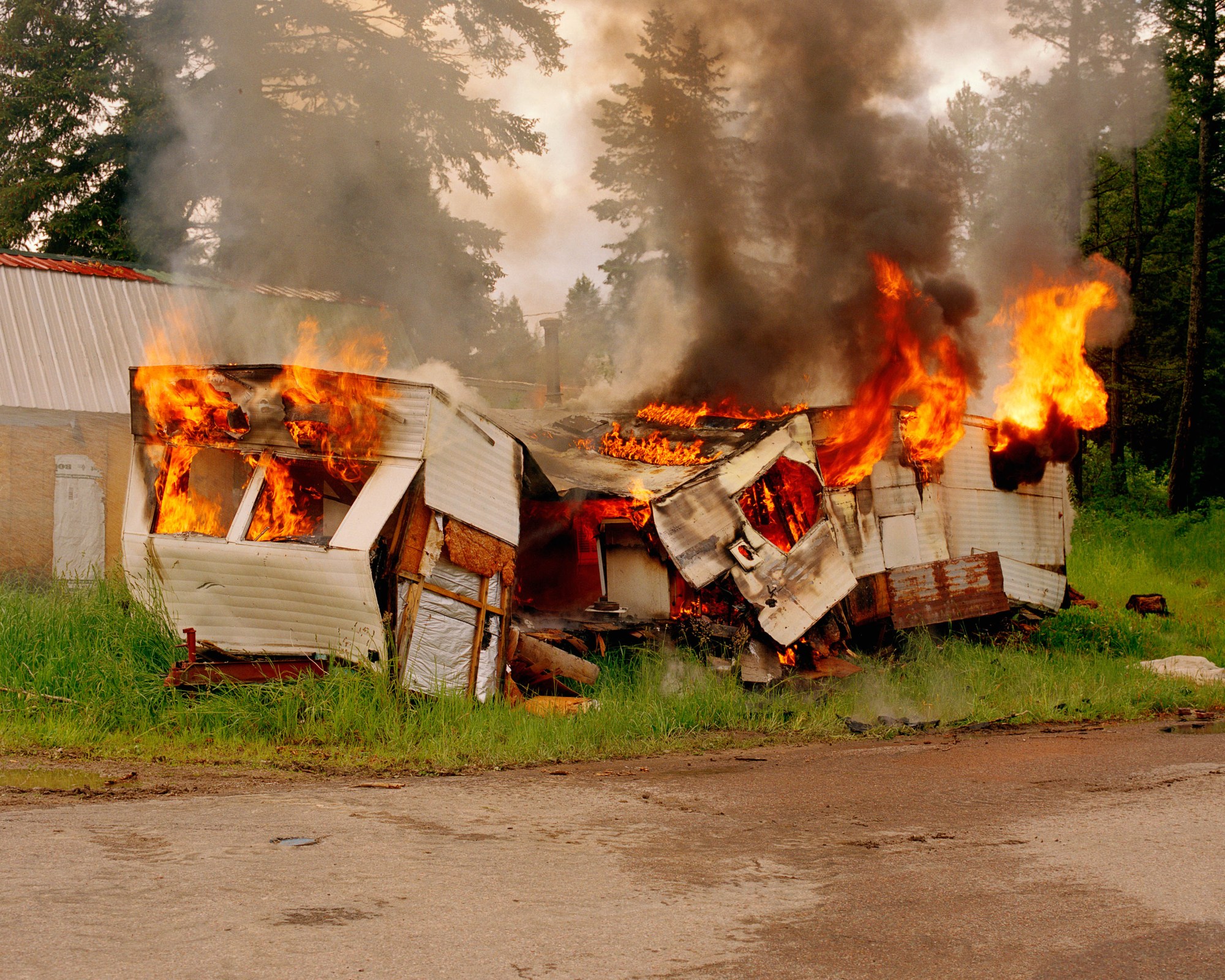 Photograph by Caroline Tompkins of a mobile trailer home on fire.