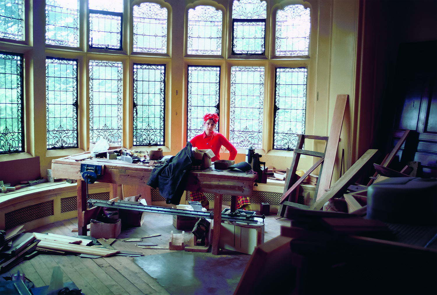 pattie boyd in her office at home wearing a red dress and matching red headscarf