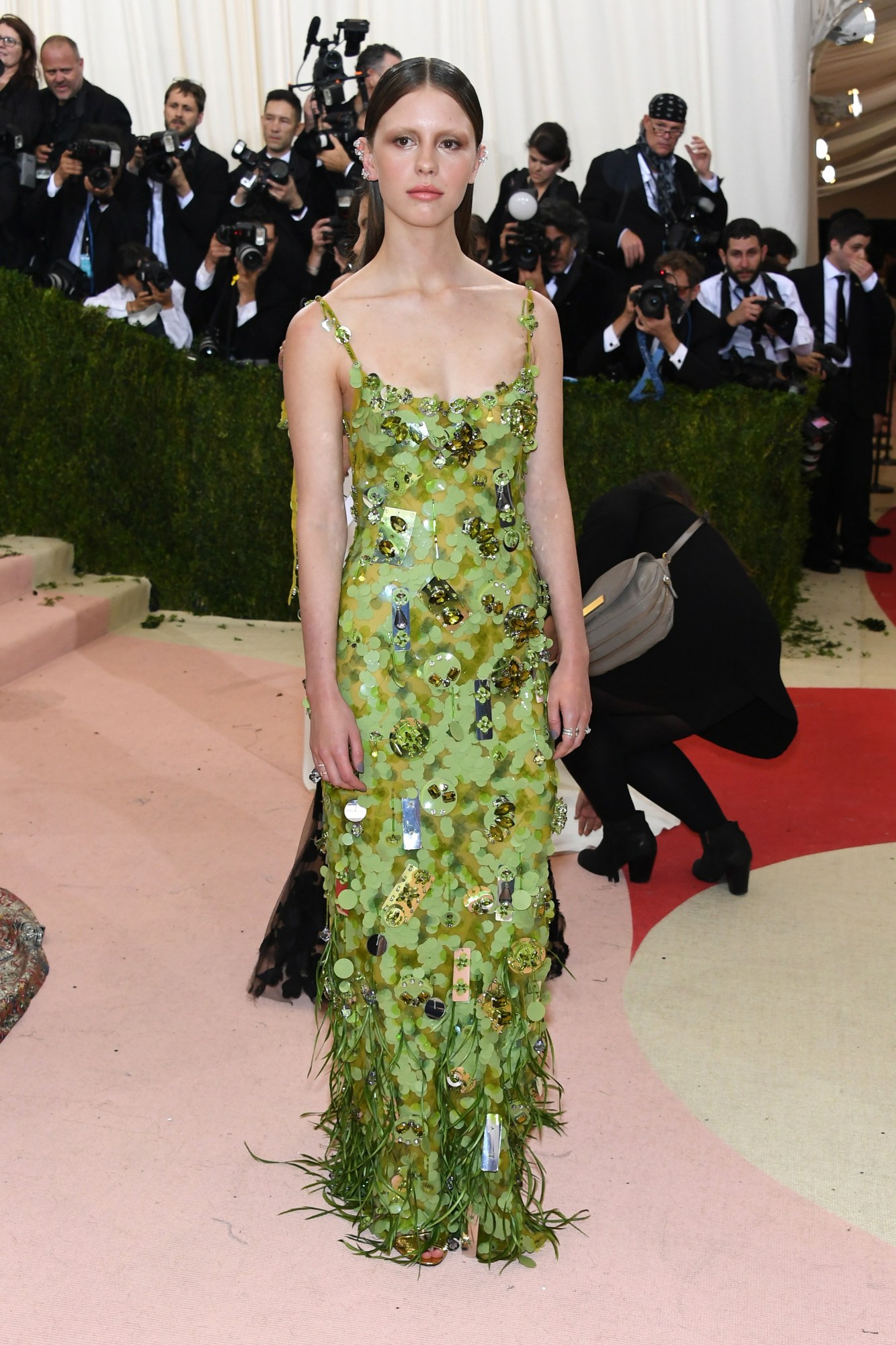 mia goth posing on the met gala red carpet in a green prada paillette dress 2016