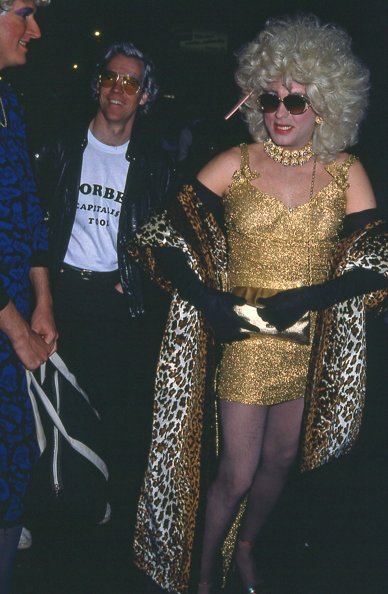 During New York's annual Village Halloween Parade, two costumed people (one dressed as 'capitalist tool' Malcolm Forbes and another in a platinum wig, gold dress, and leopard-print wrap)