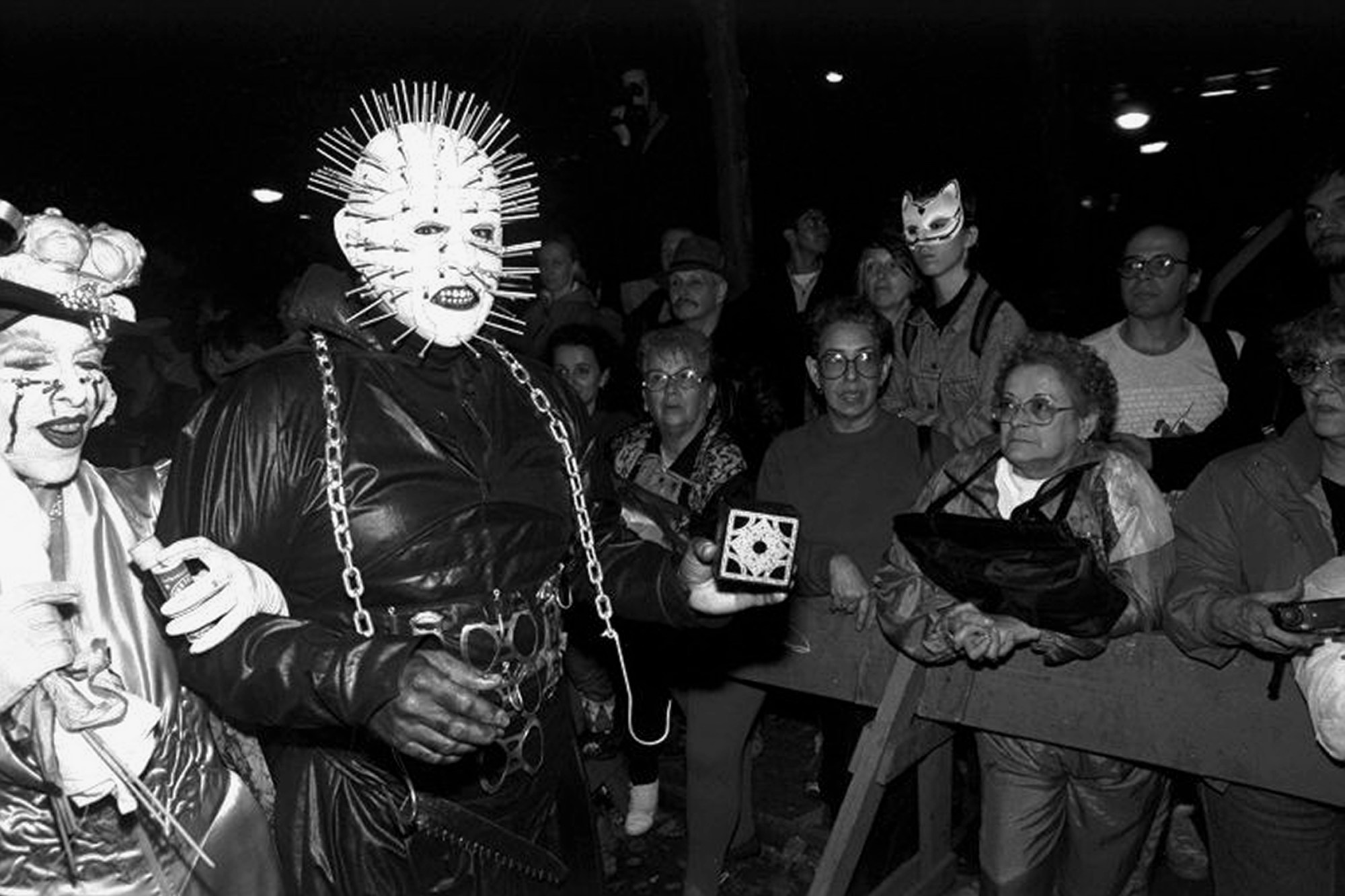 two revellers march the greenwich village halloween parade, one dressed in all leather as hellraiser