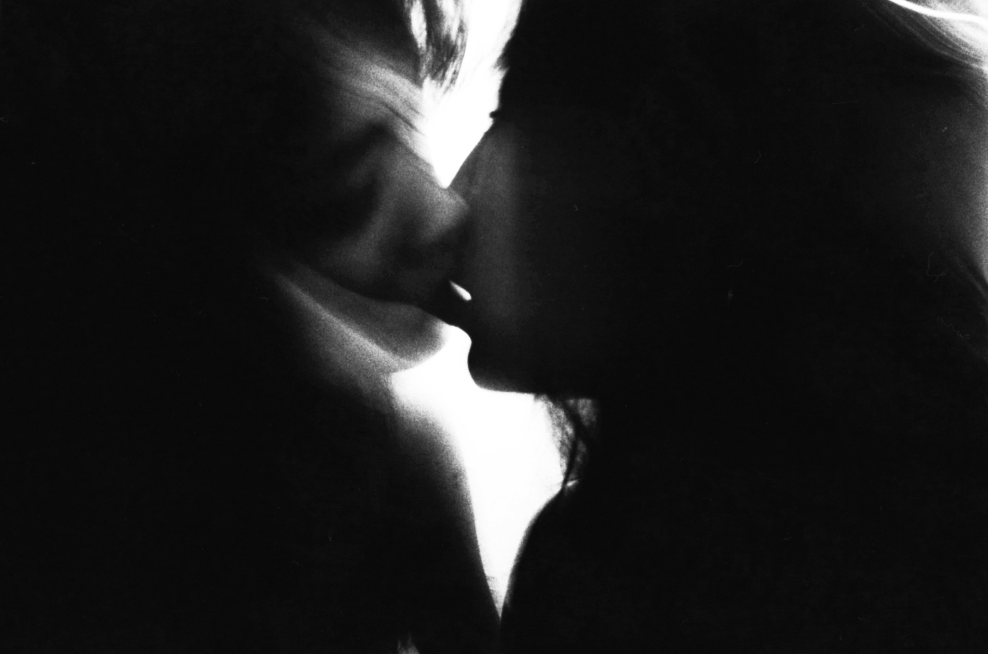 two lovers kissing in a blurred abstracted black and white photograph