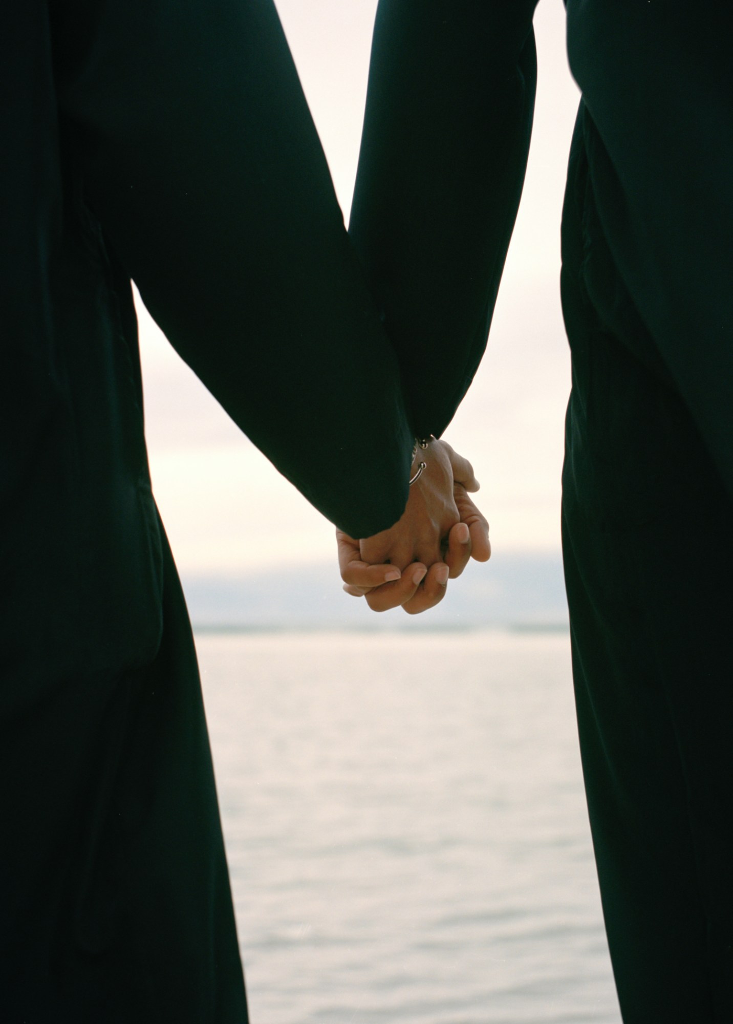 Two lovers holding hands on the beach