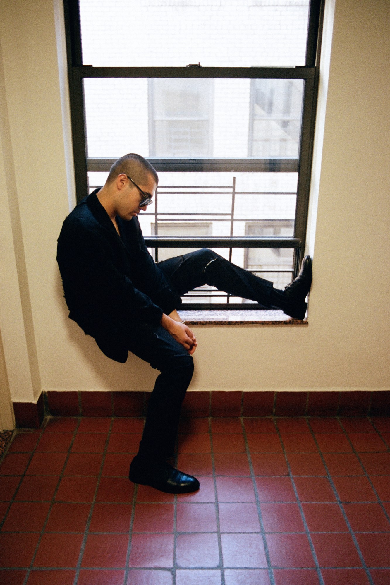 blaketheman1000 sitting in a window frame in all black