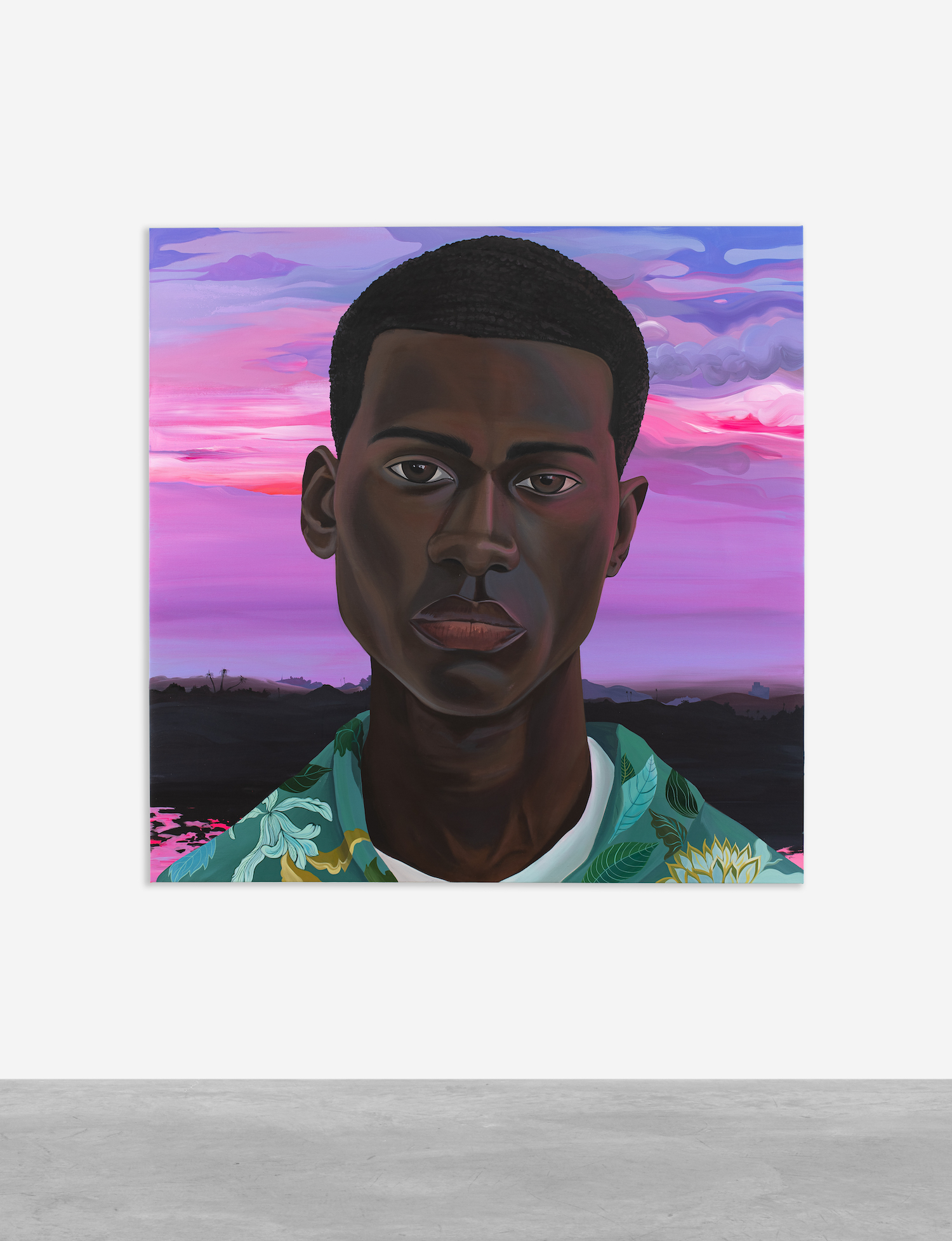 A portrait of a person wearing a tropical shirt standing in front of a pink and purple sunset