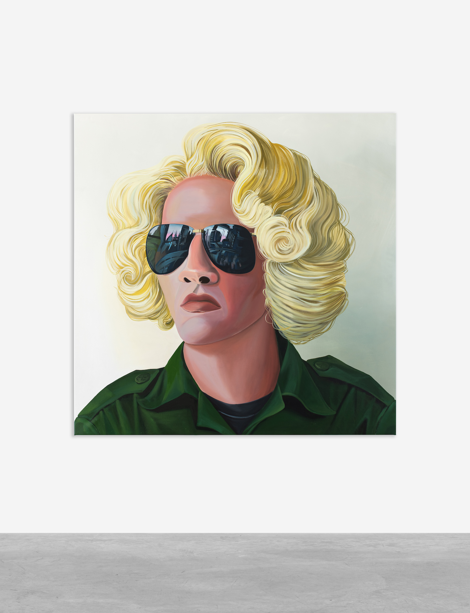 A portrait of a person with blond curly hair wearing aviator sunglasses