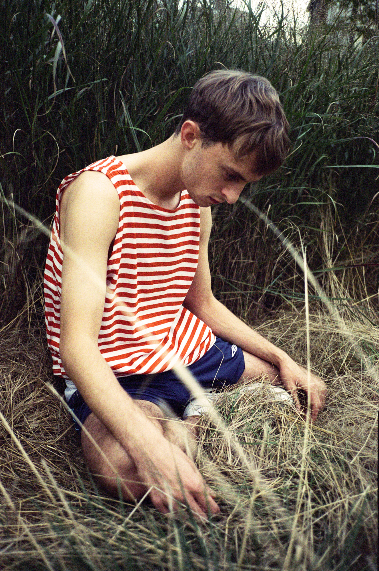 a boy names marko in a red and white striped shirt posing in tall grass