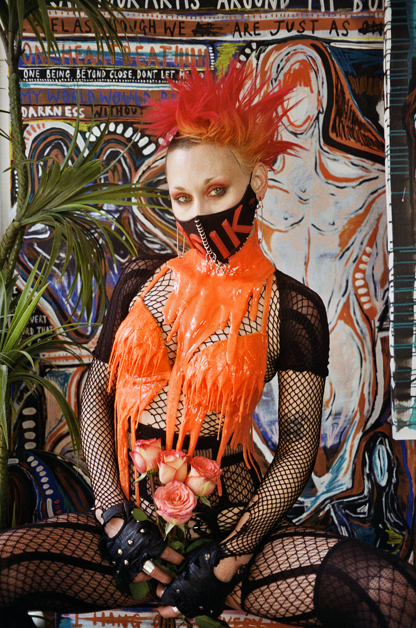 a woman with a fiery orange mohawk and fishnets