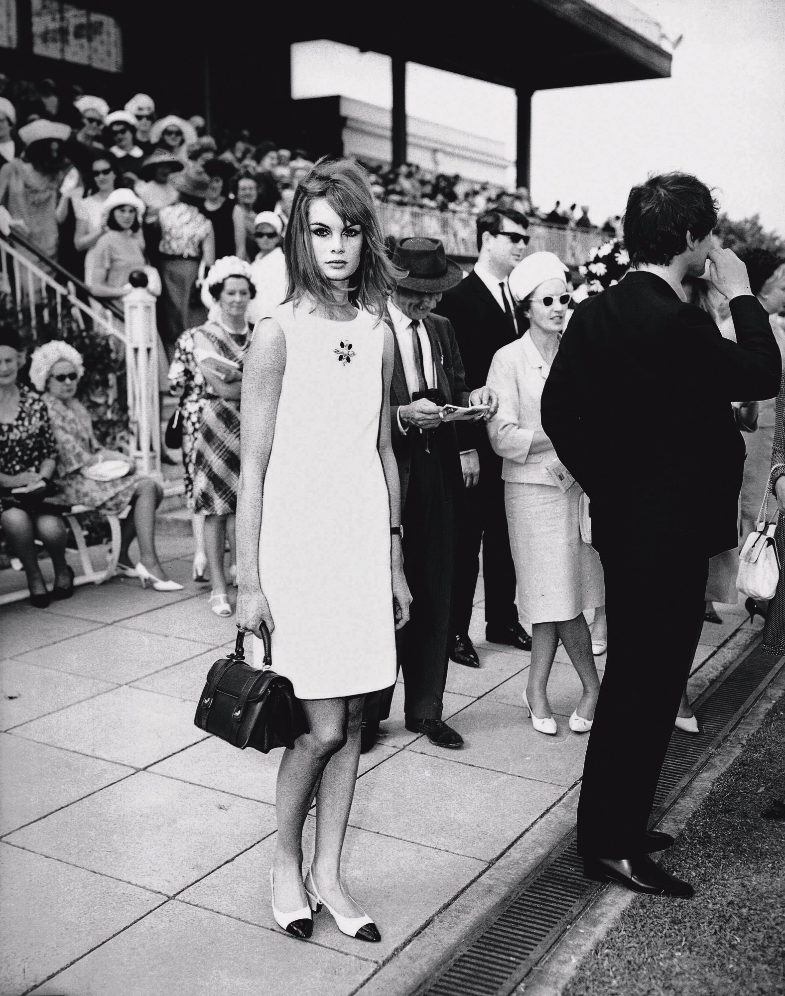 jean shrimpton standing on a sidewalk in australia wearing a white mini shift dress 1965