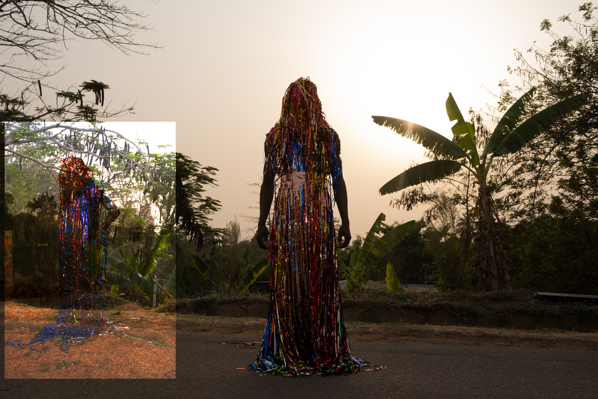 a figure wearing a sparkly multicolored outfit amongst palm trees