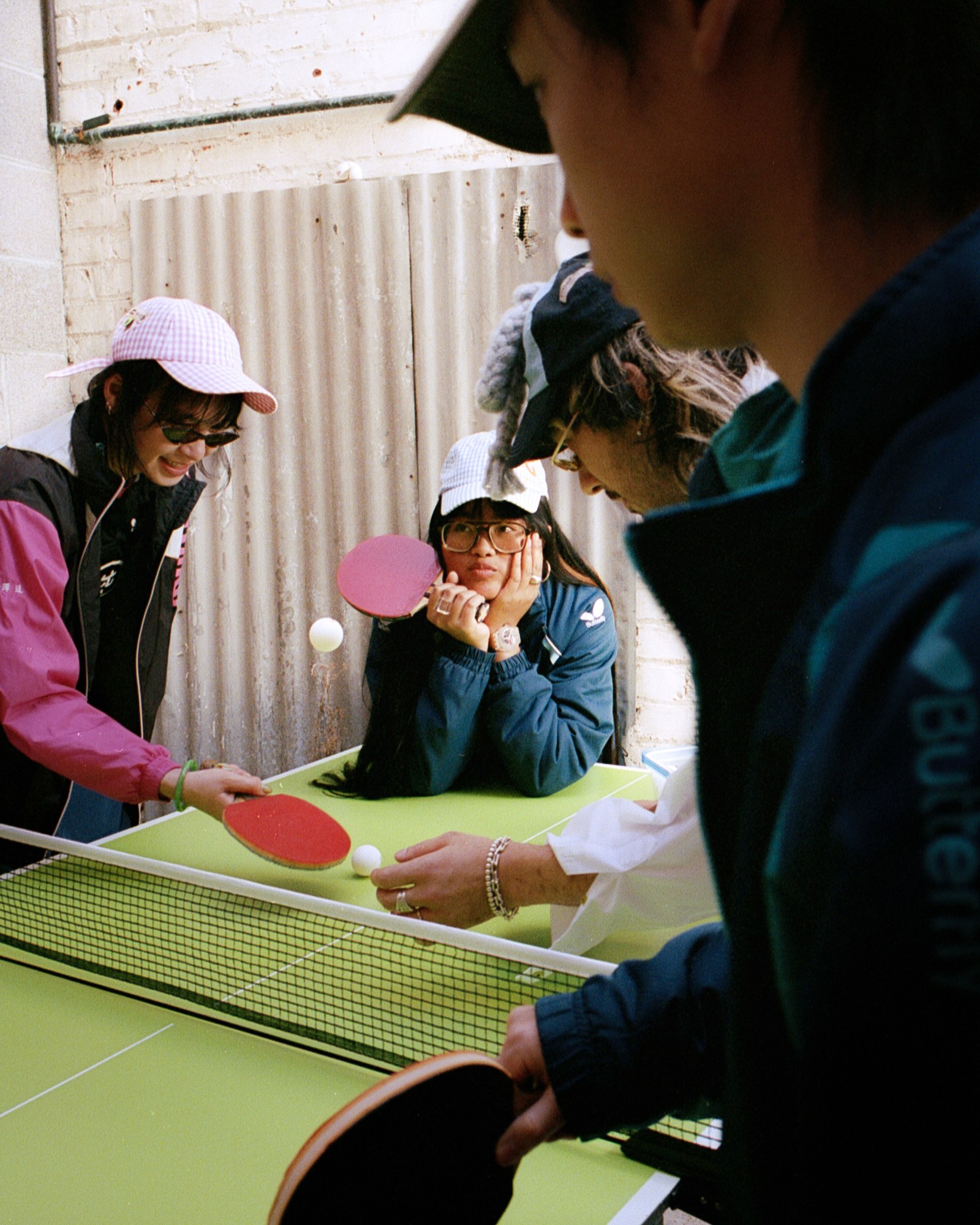 eva bella trilla with her hands resting on her face across a ping-pong table