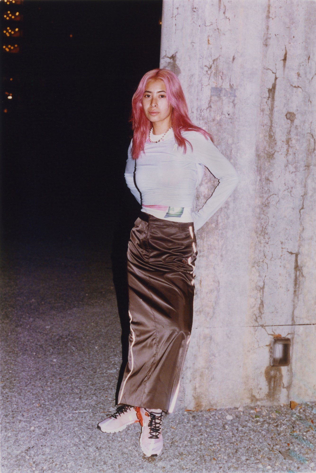 portrait of michelle li leaning against a concrete wall