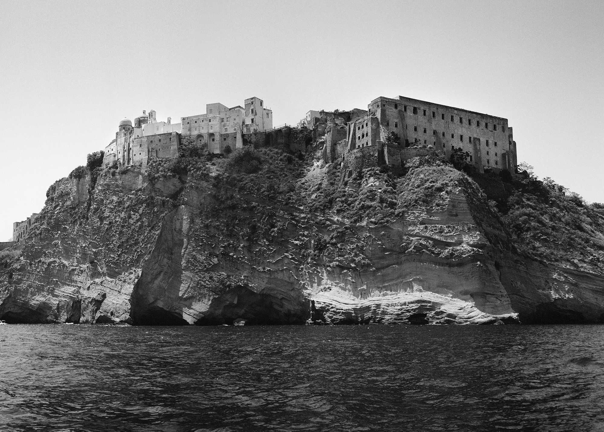 a dramatic cliff edge with old buildings built into it