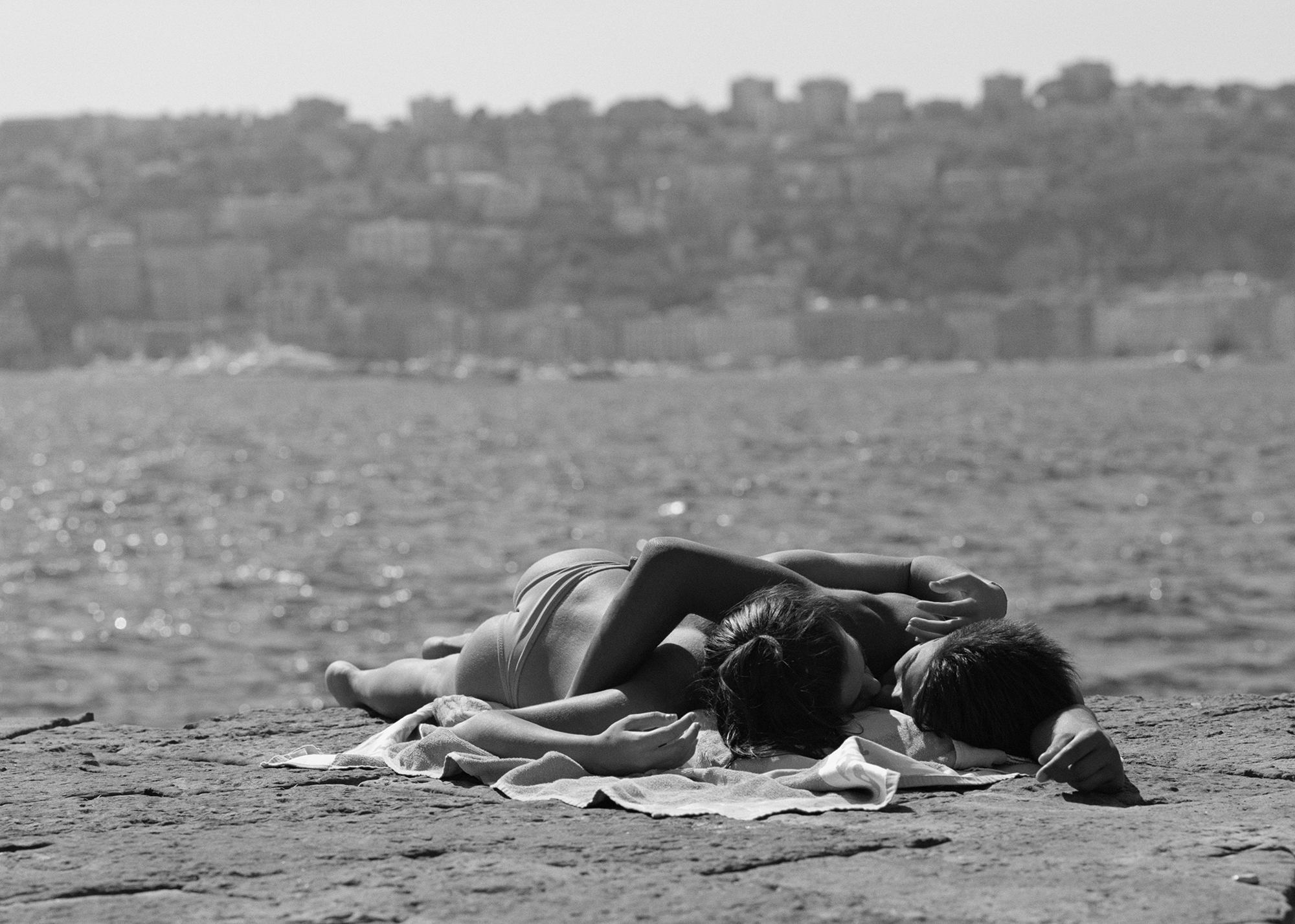 a couple embrace on an empty beach