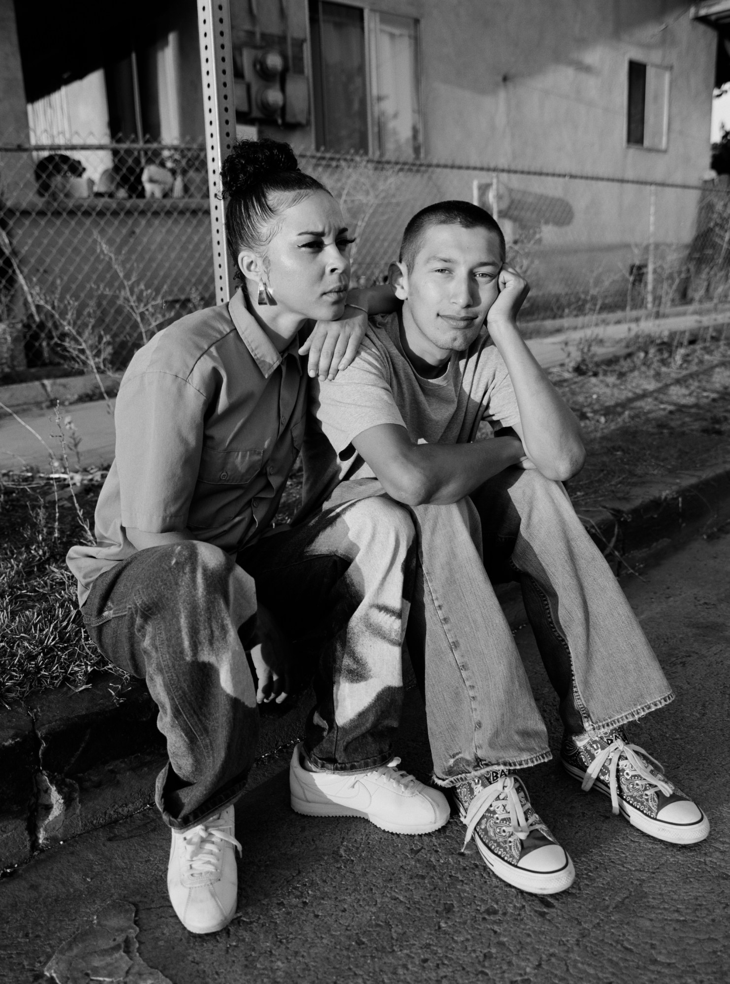 two afro-latino teenagers sitting on a stoop in los angeles