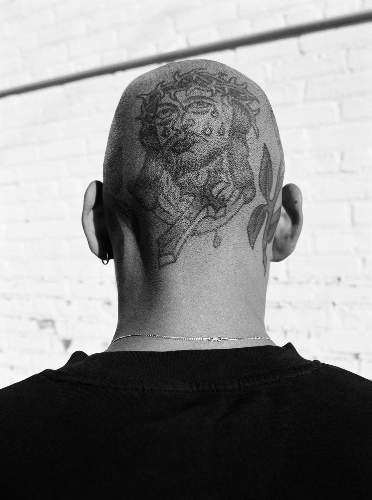 a back of a man's head with tattoos in black and white