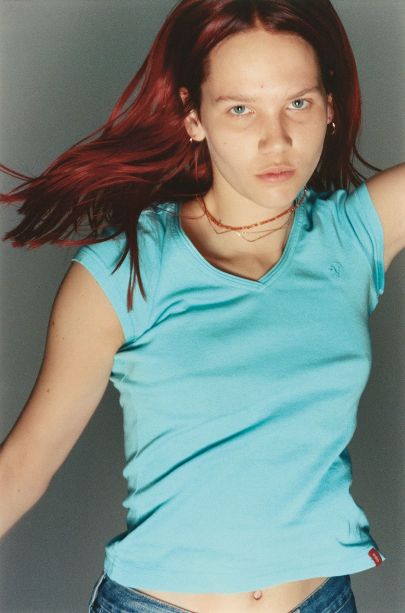 a teenage girl with red hair wearing a blue tshirt caught in motion, dancing