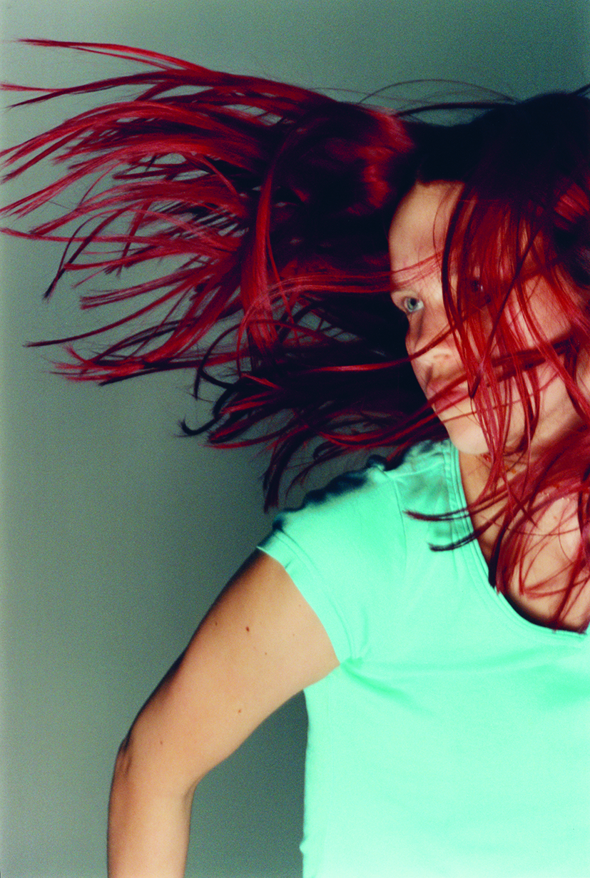 a red-haired teen girl dances in a studio