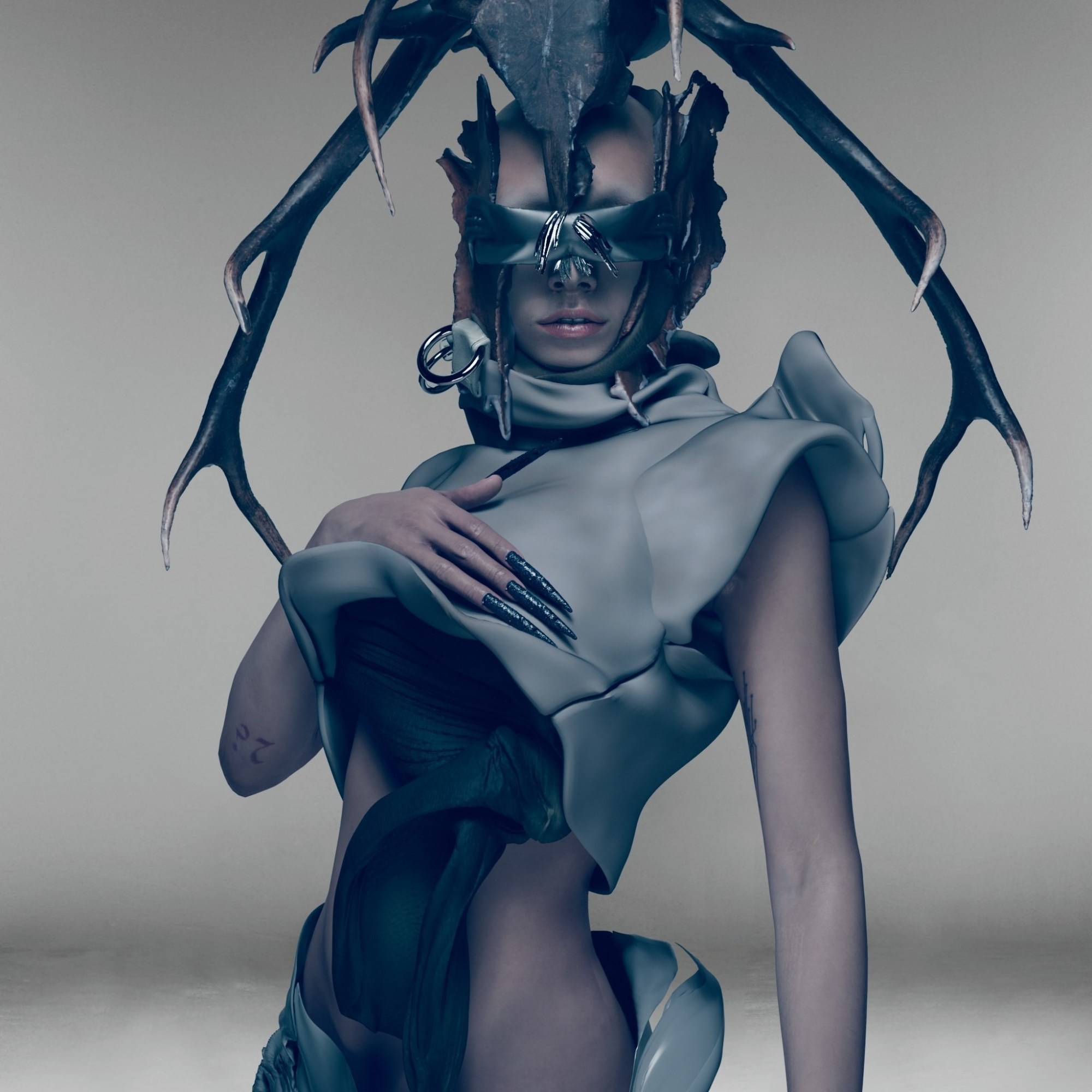 A digital render of model Jazzelle Zanaughtti wearing a carapace like digital garment and a headpiece