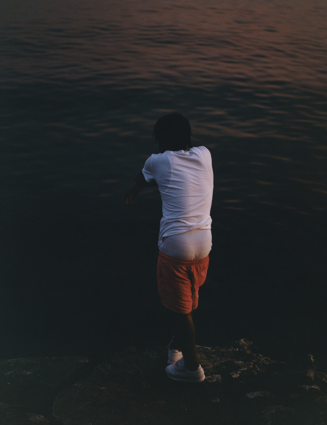 Balla standing on rocks by the ocean early in the morning photographed by Jeano Edwards for i-D’s The Royalty Issue, no. 370, Winter 2022