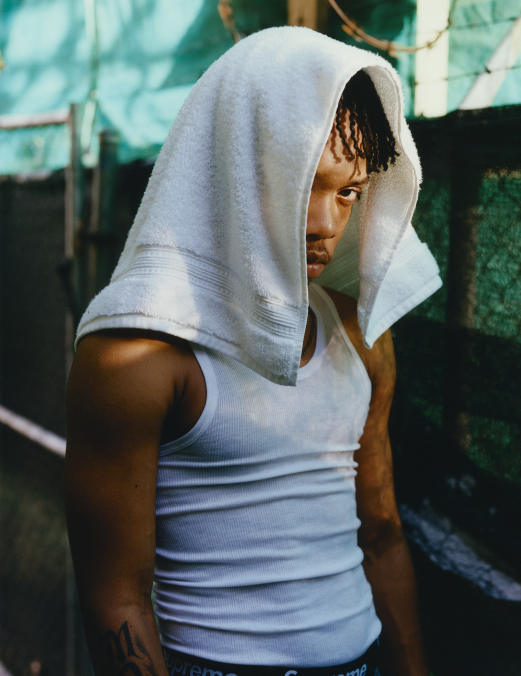 Bayka in a vest with a towel on his head photographed by Jeano Edwards for i-D’s The Royalty Issue, no. 370, Winter 2022