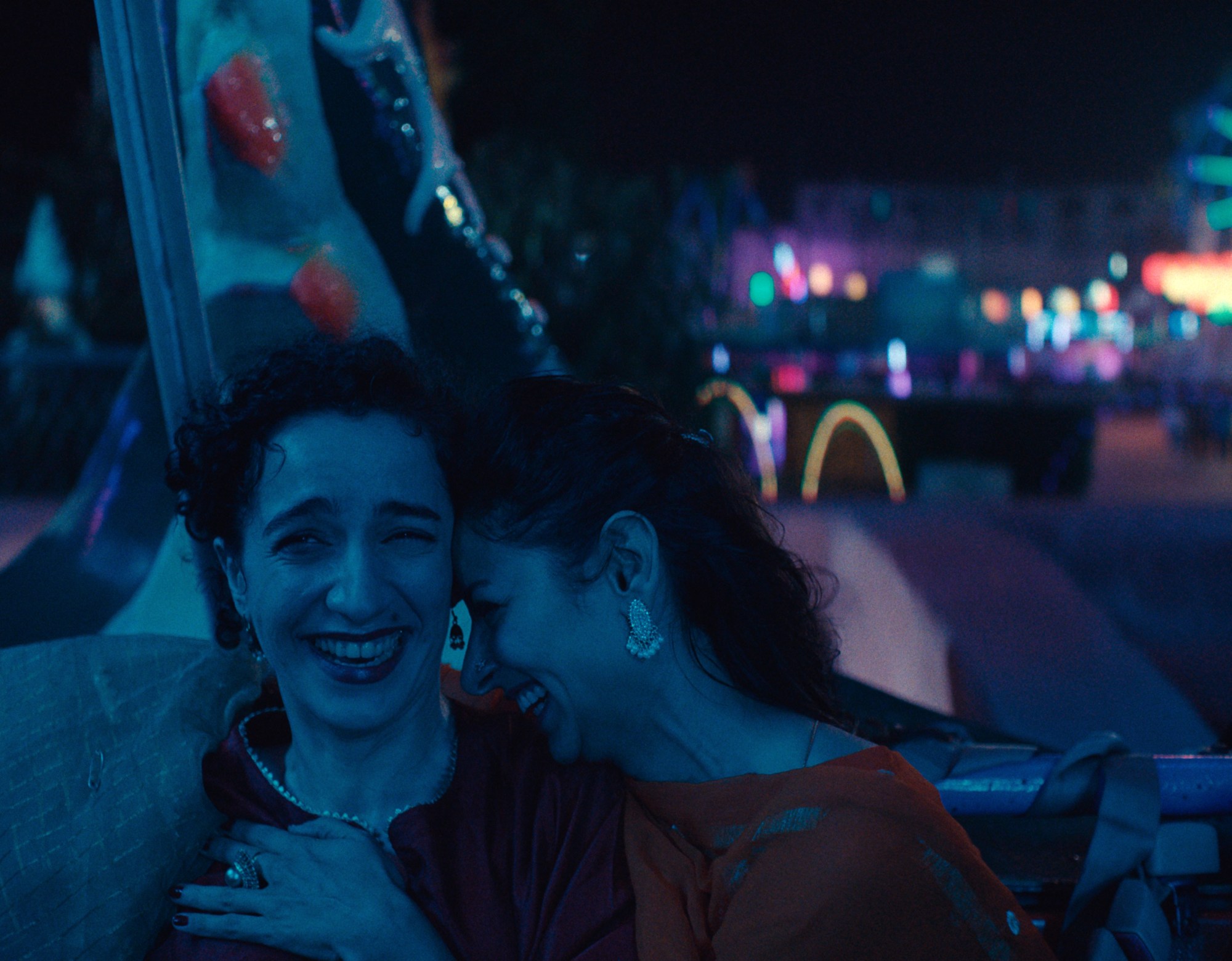 two women hold each other on a fairground ride