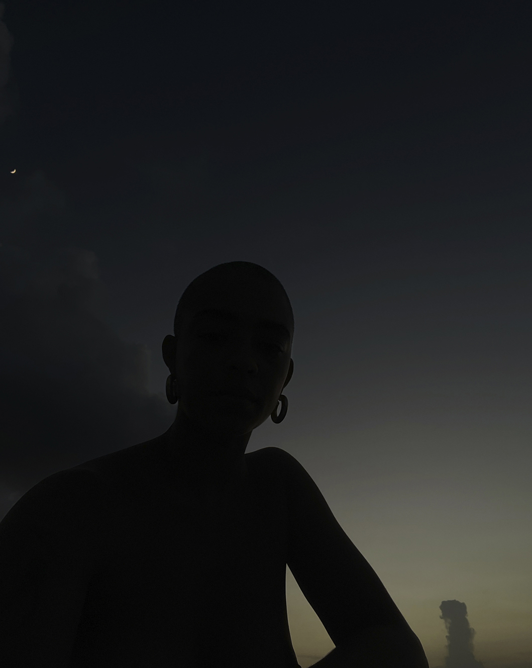 kelsey lu's silhouette at dusk. they are wearing earrings for i-D’s The Royalty Issue, no. 370, Winter 2022