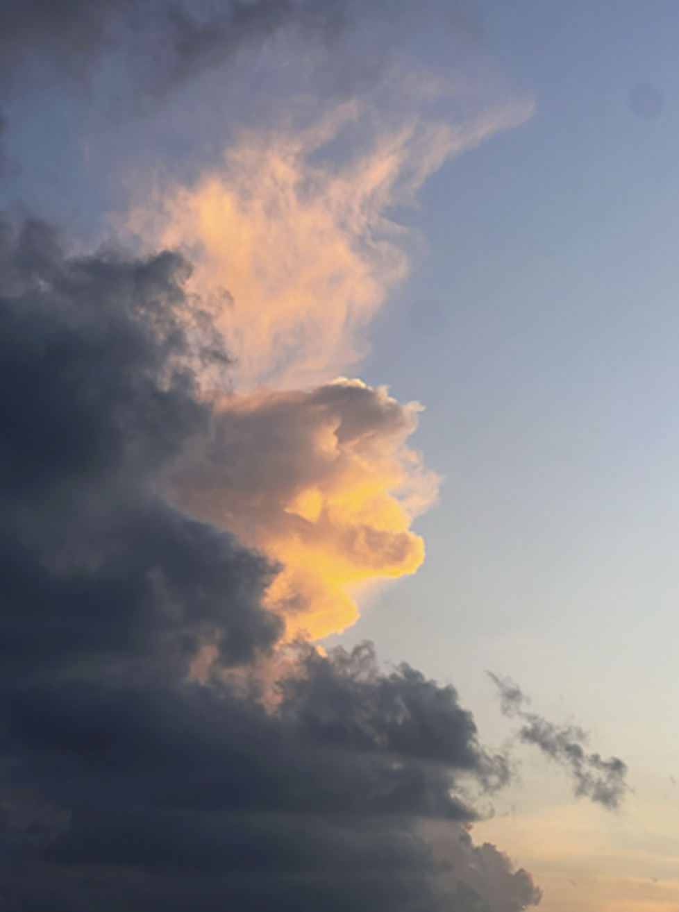 Photography by Kelsey Lu of clouds both grey and lit by the sun layered in against a blue sky for i-D’s The Royalty Issue, no. 370, Winter 2022