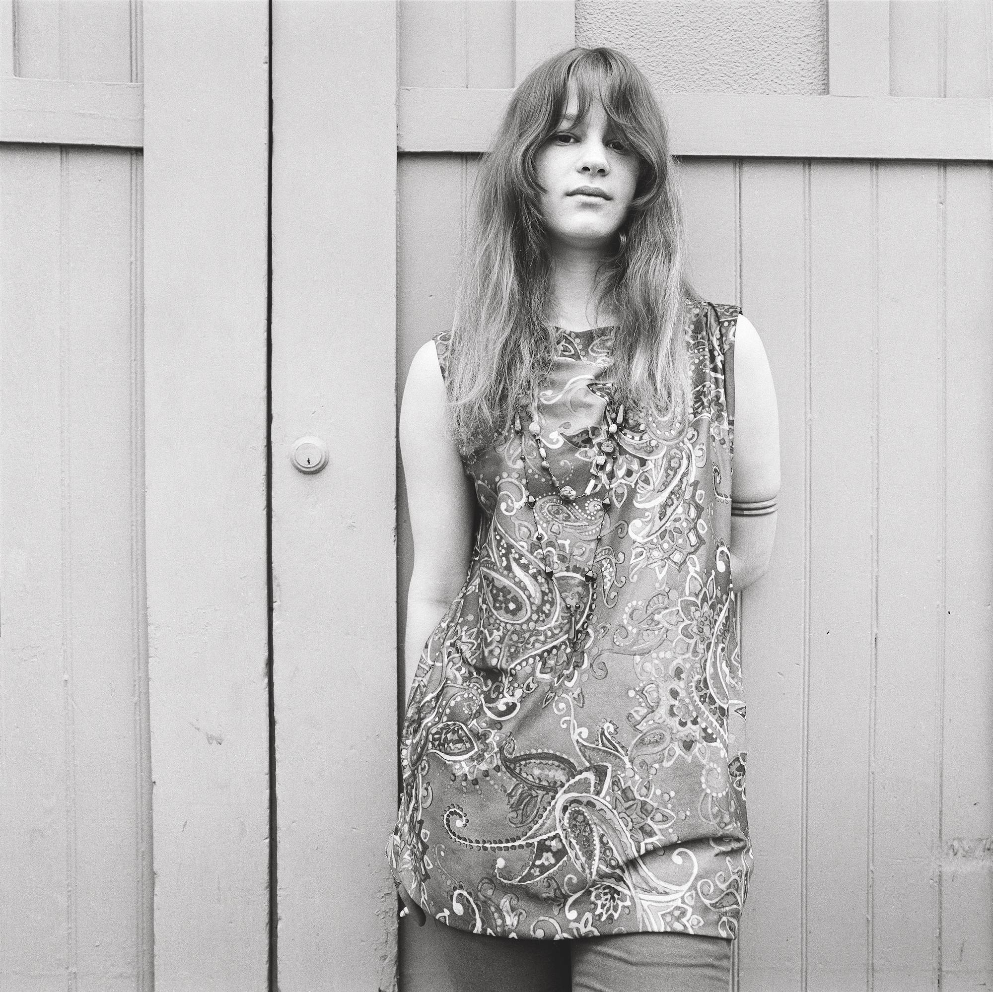 black-and-white photo of a woman in a paisley print dress from the 1960s