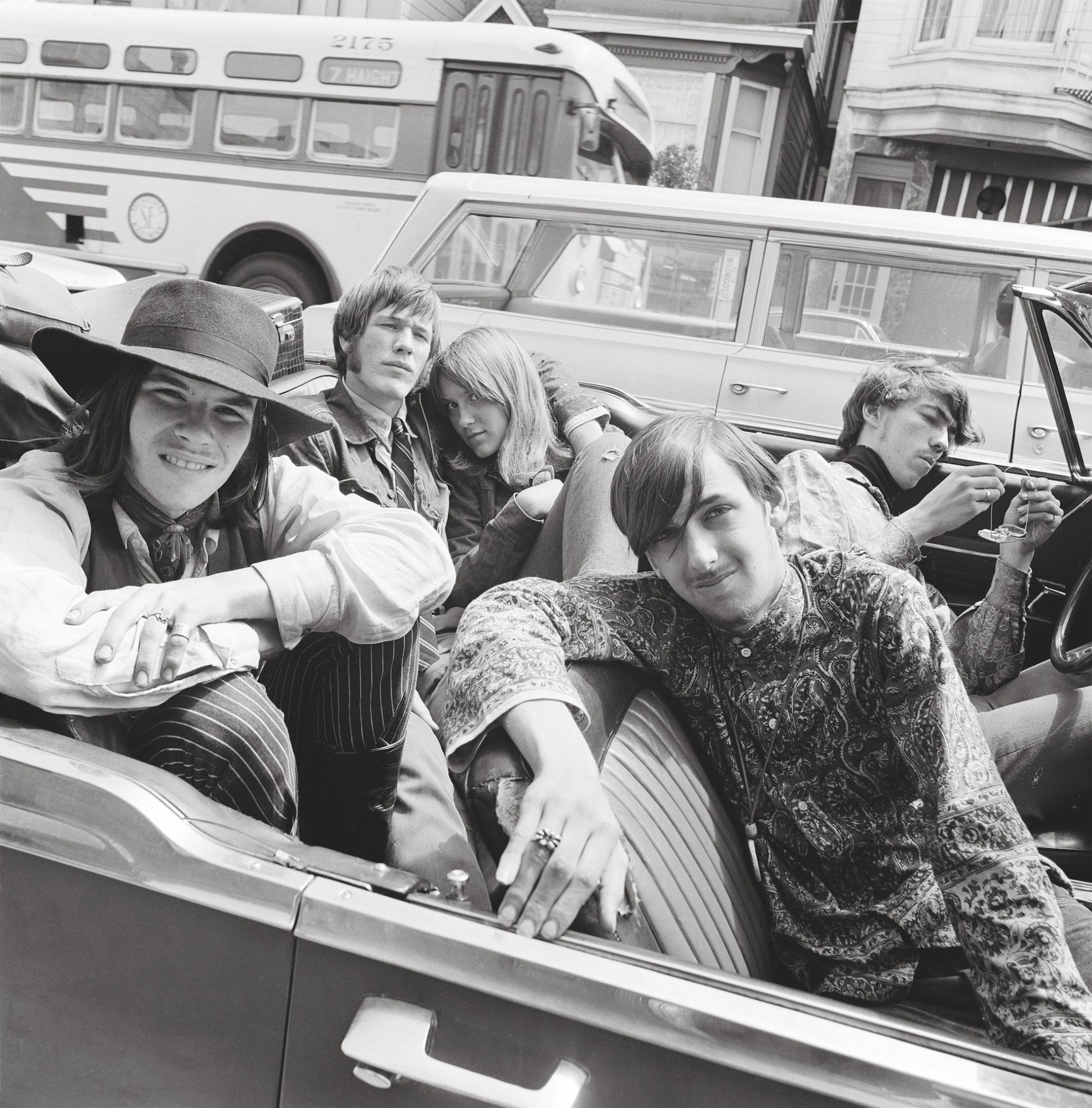 black-and-white image of 1960s teenagers in an open top convertible car