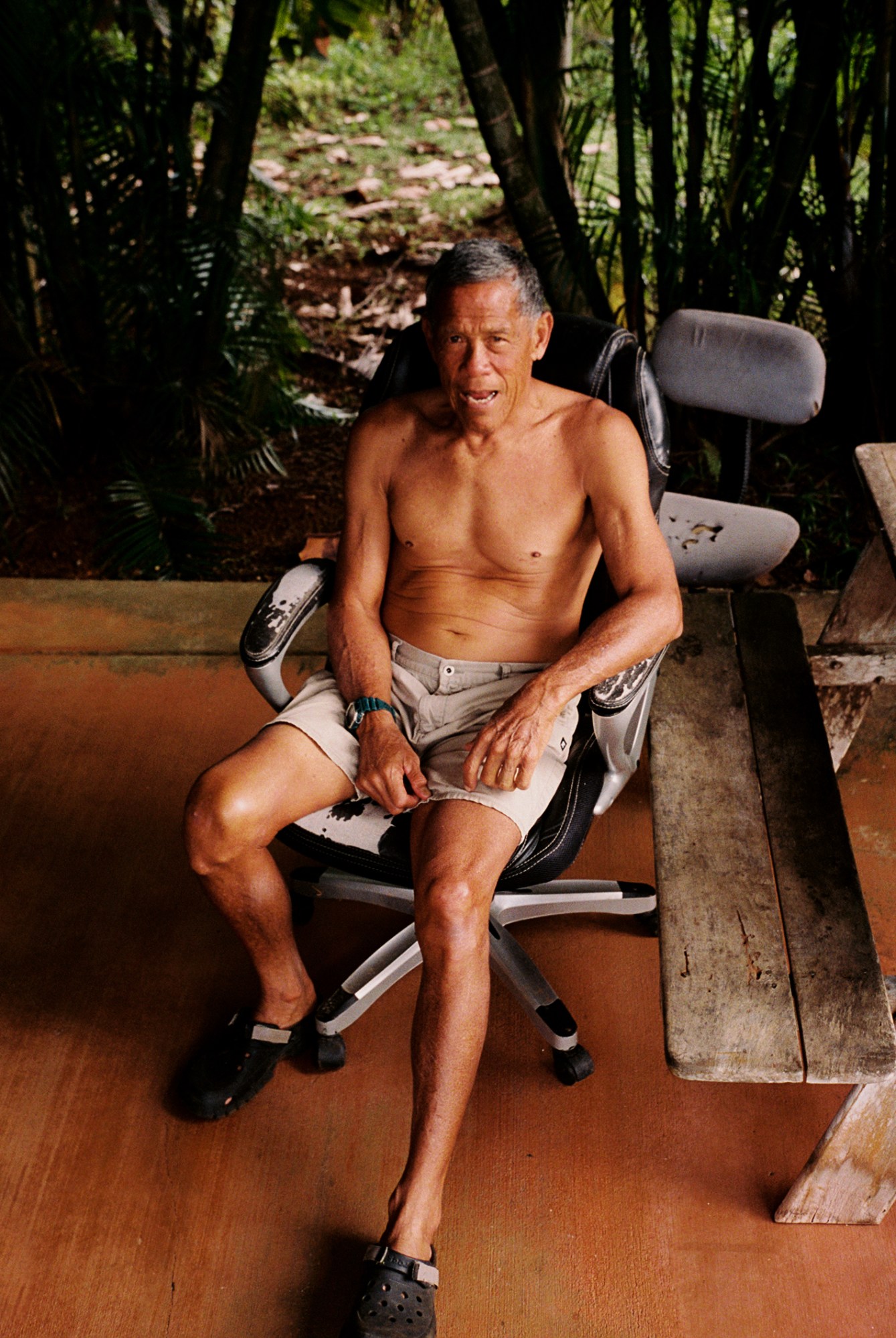 an old man sitting in a spinning chair on wooden floors