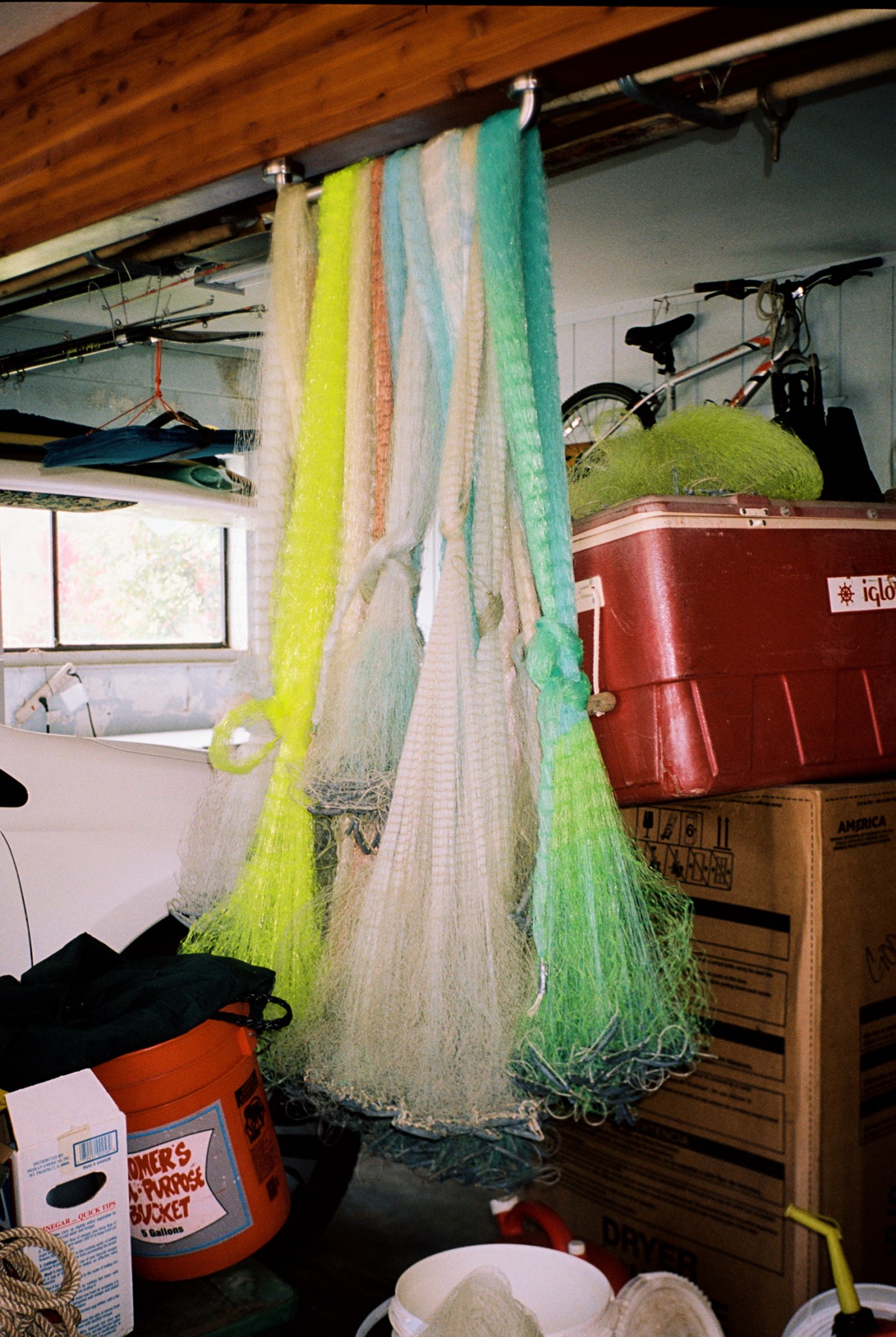 fishing nets hanging from the rafters surrounded by bins