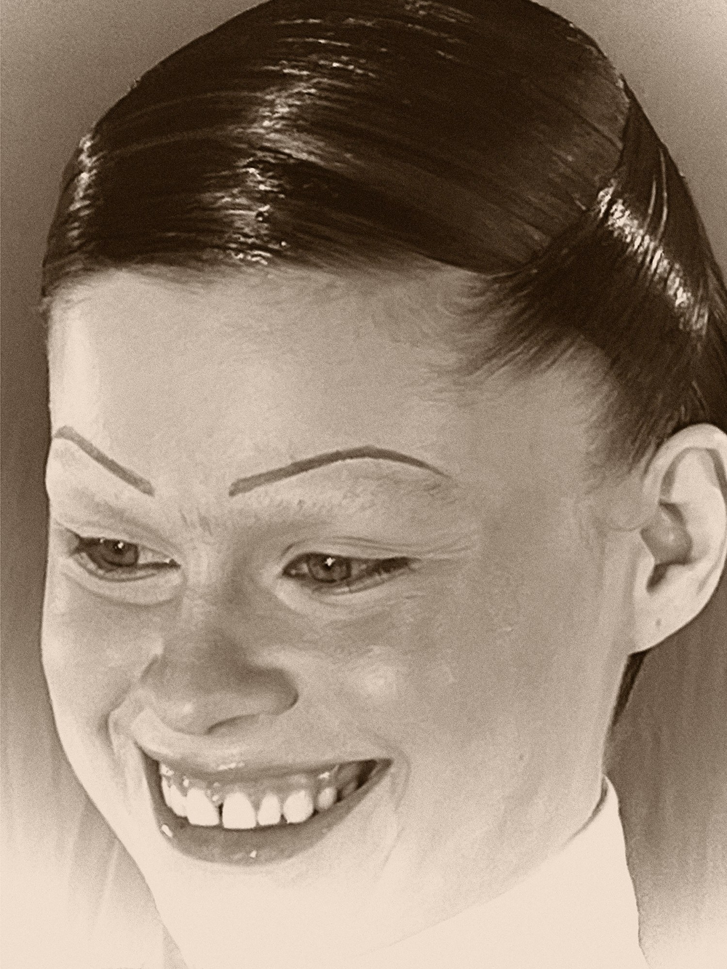 facial close up of a woman with extremely slicked back hair