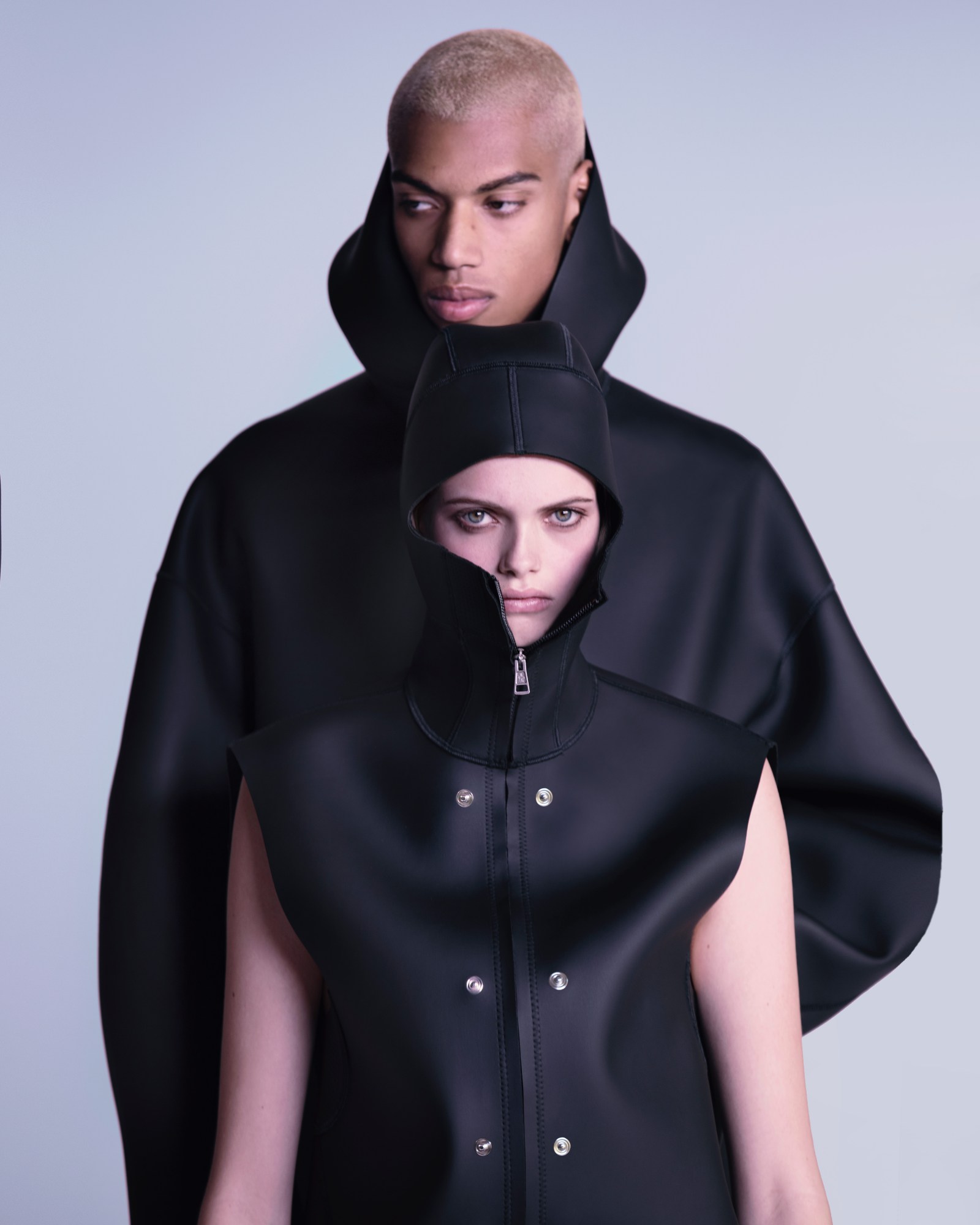 two models in neoprene hooded jackets in a studio