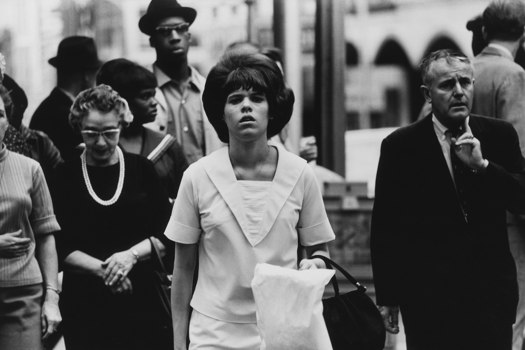 men and women in classic 60s clothing cross the street