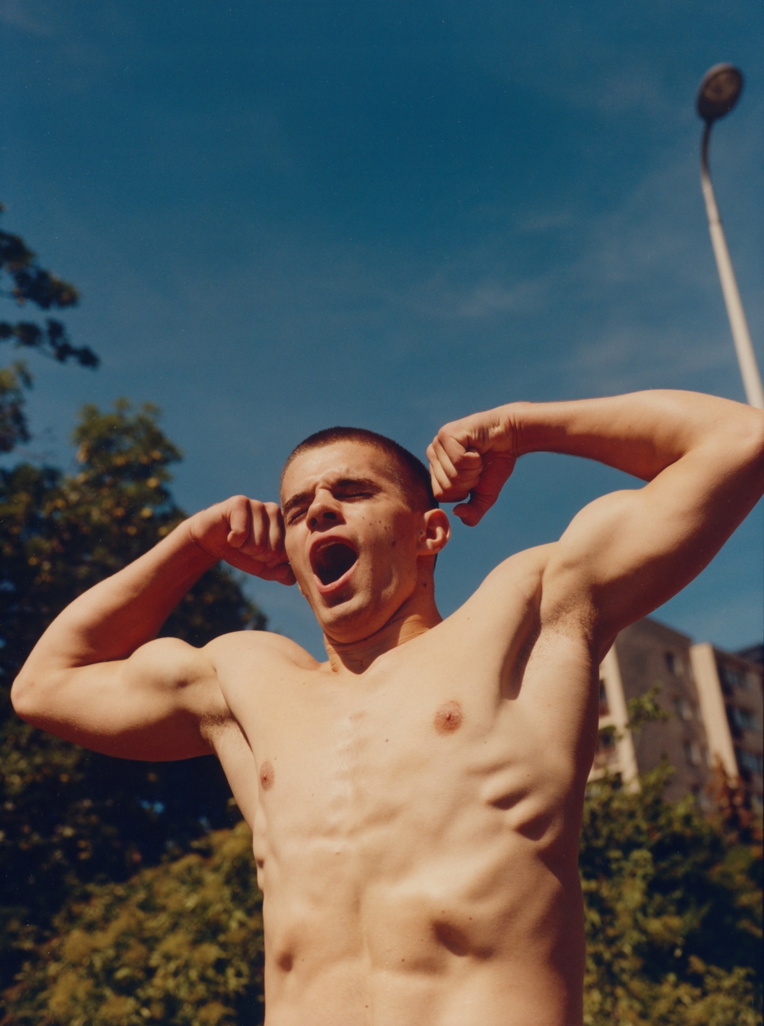 A toned teenager tensing his muscles