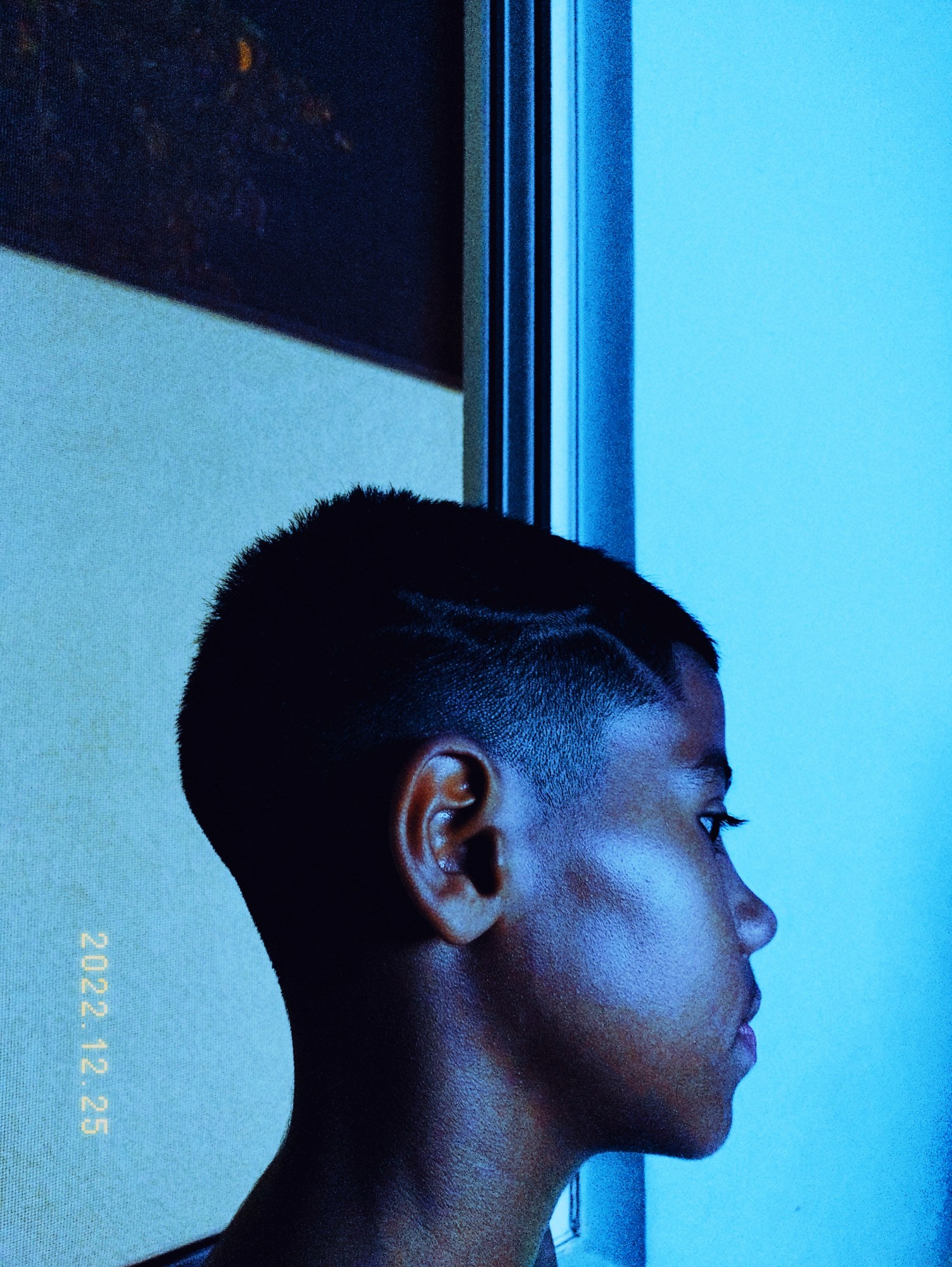 a young boy shot in profile in blue tones