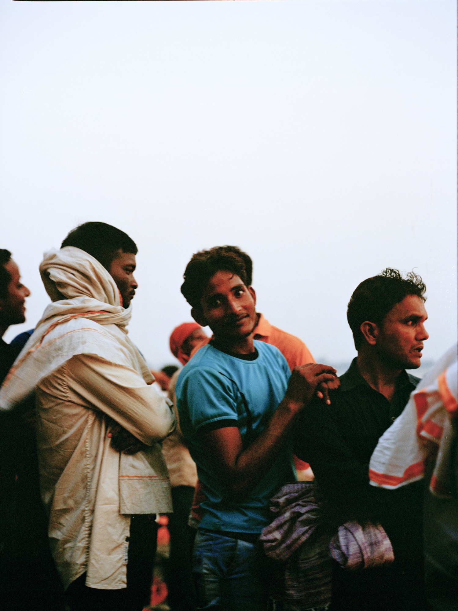 men in the crowd at manikarnika ghat, india