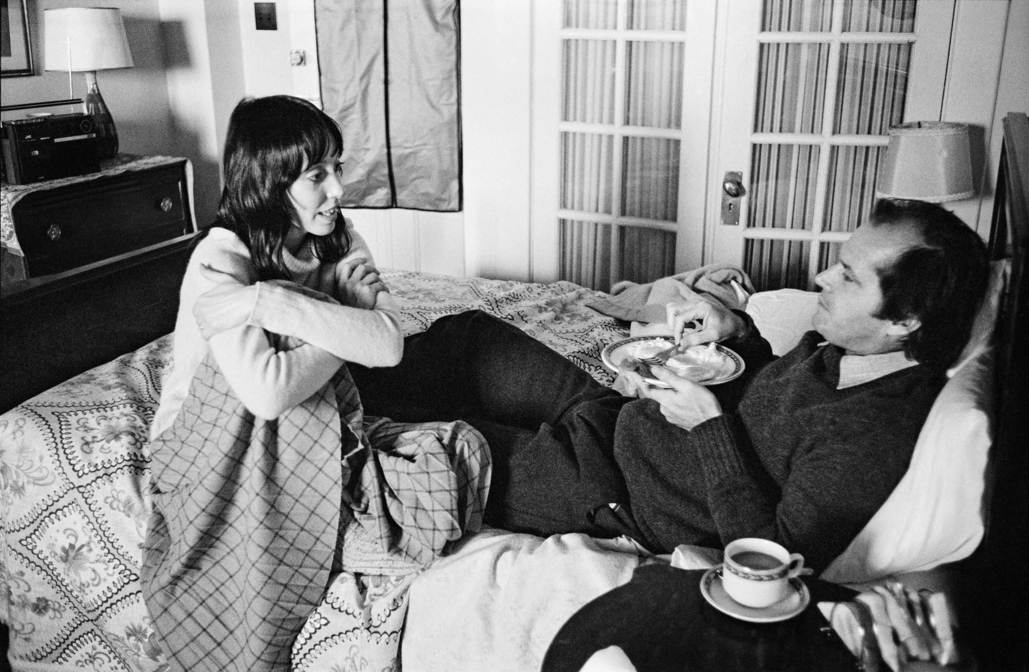 a behind the scenes photo of shelley duvall and jack nicholson talking on the set of the shining