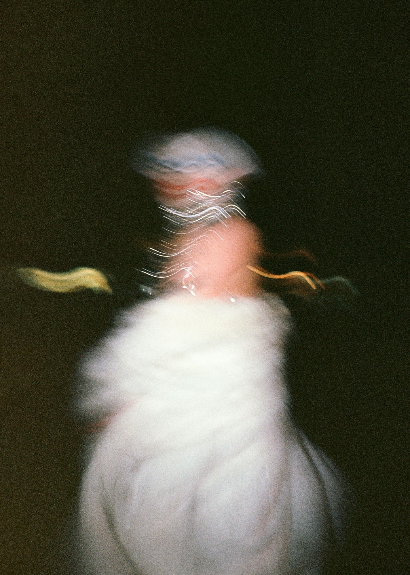 blurry over-exposed image of a drag queen in a white fur coat