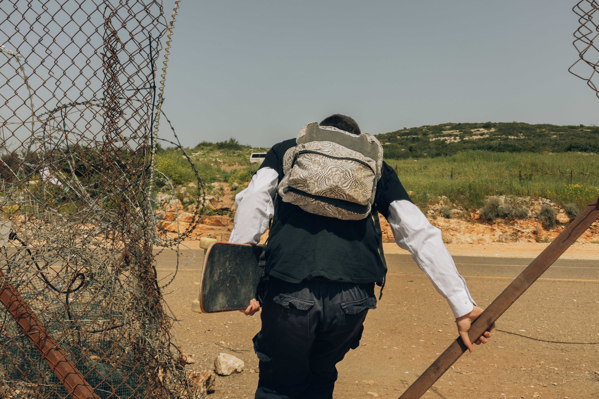 A young man skateboaring on an empty street in Palestine