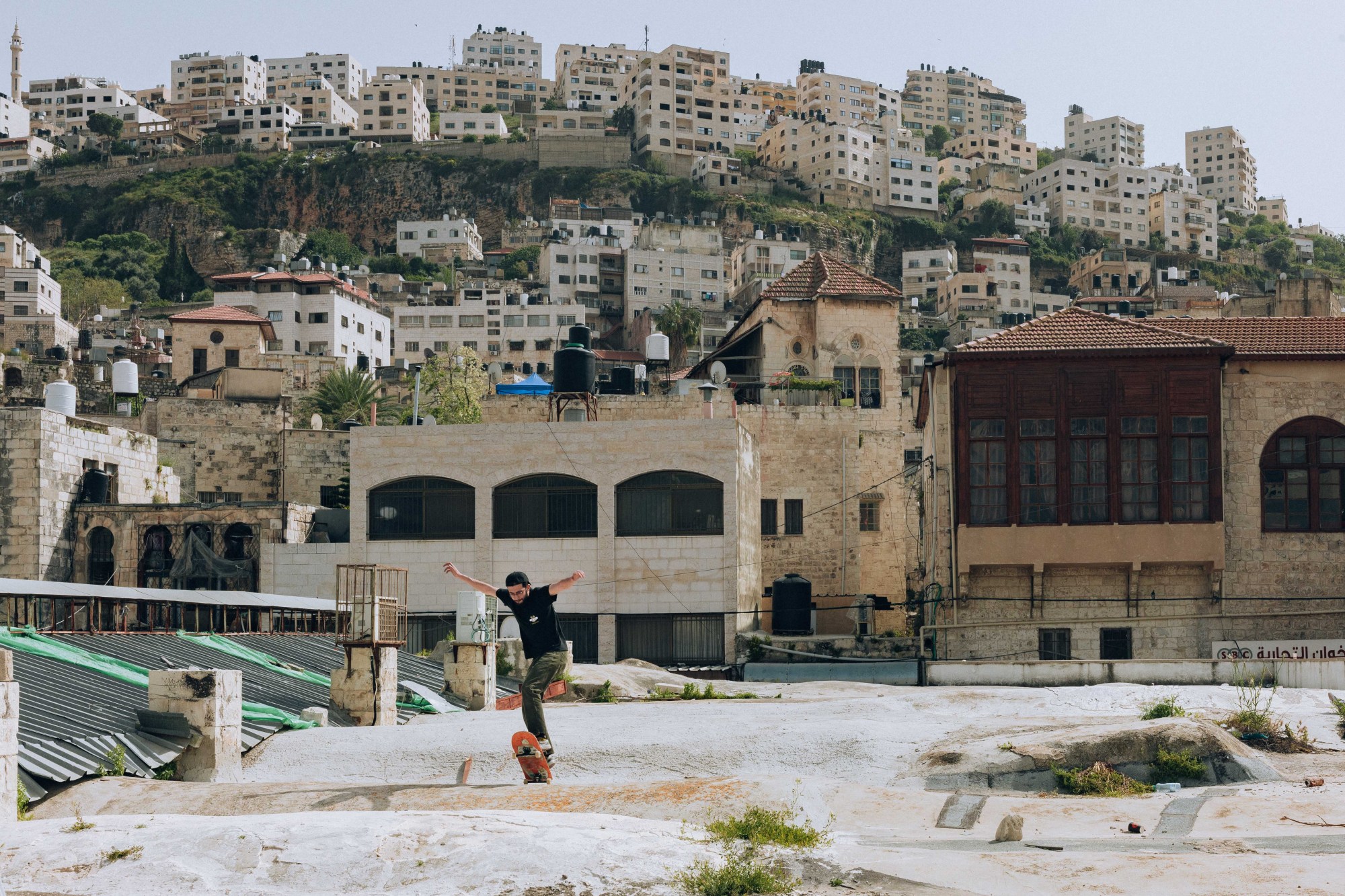 A young man skateboaring in an empty park in Palestine.