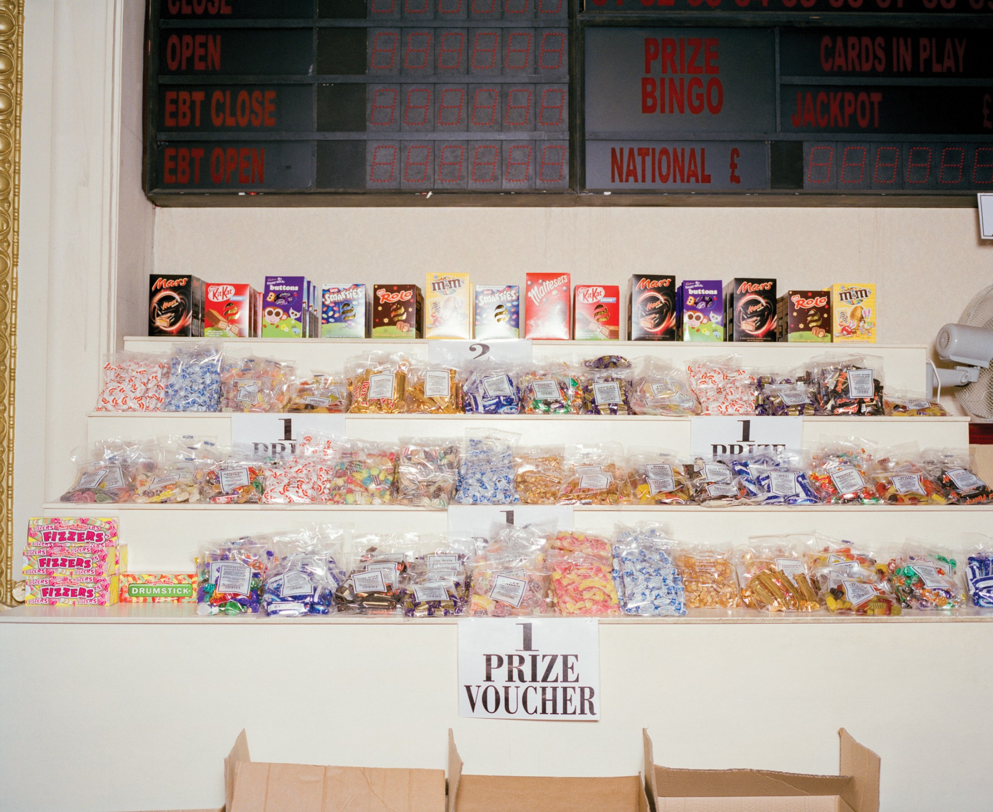 candy on white shelves and a sign that reads 1 prize voucher