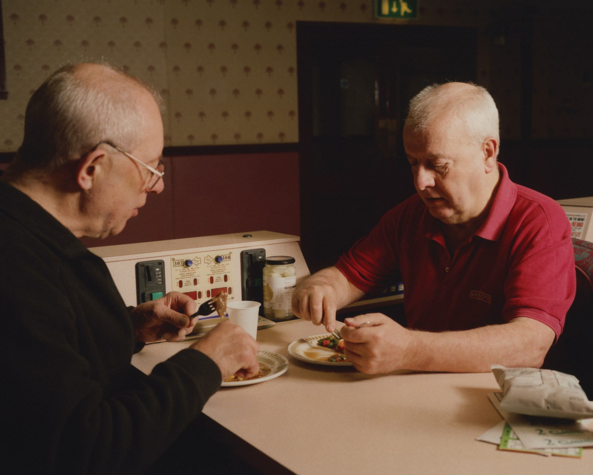 two men eating at a bing table at new western bingo hall in leeds