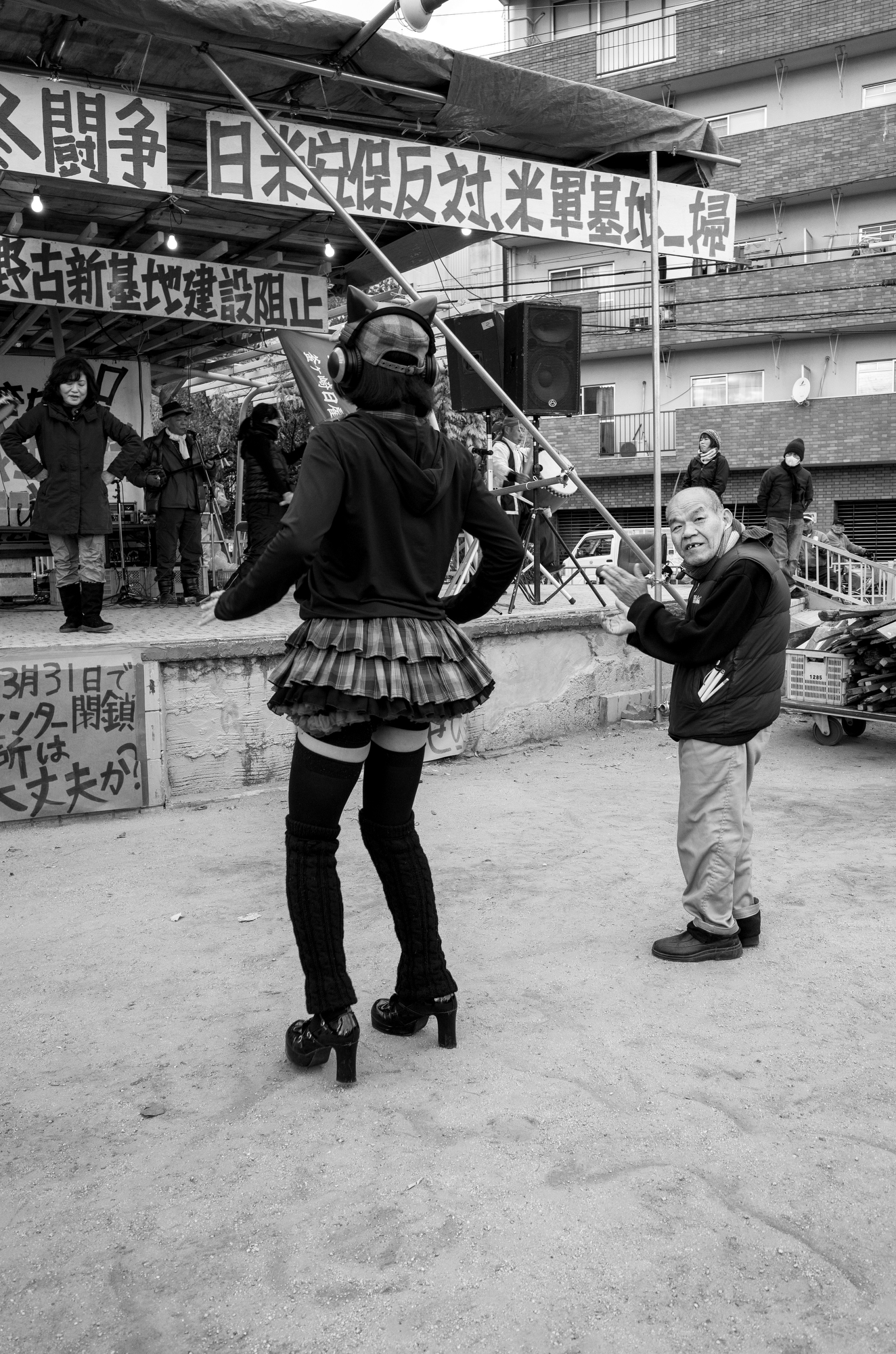 black-and-white image of a town square, people are dancing in the foreground