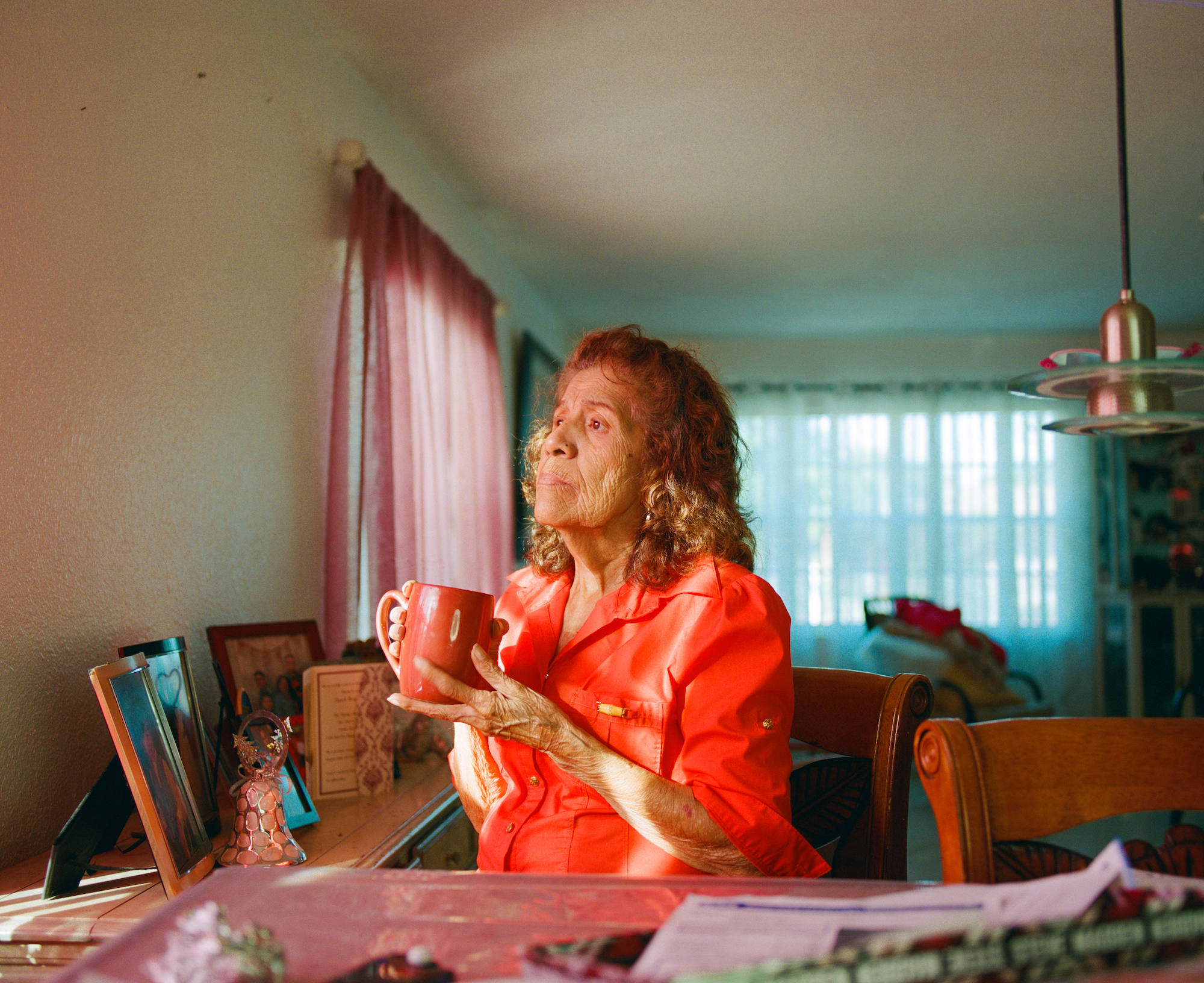 a woman in red holding a red mug at a table