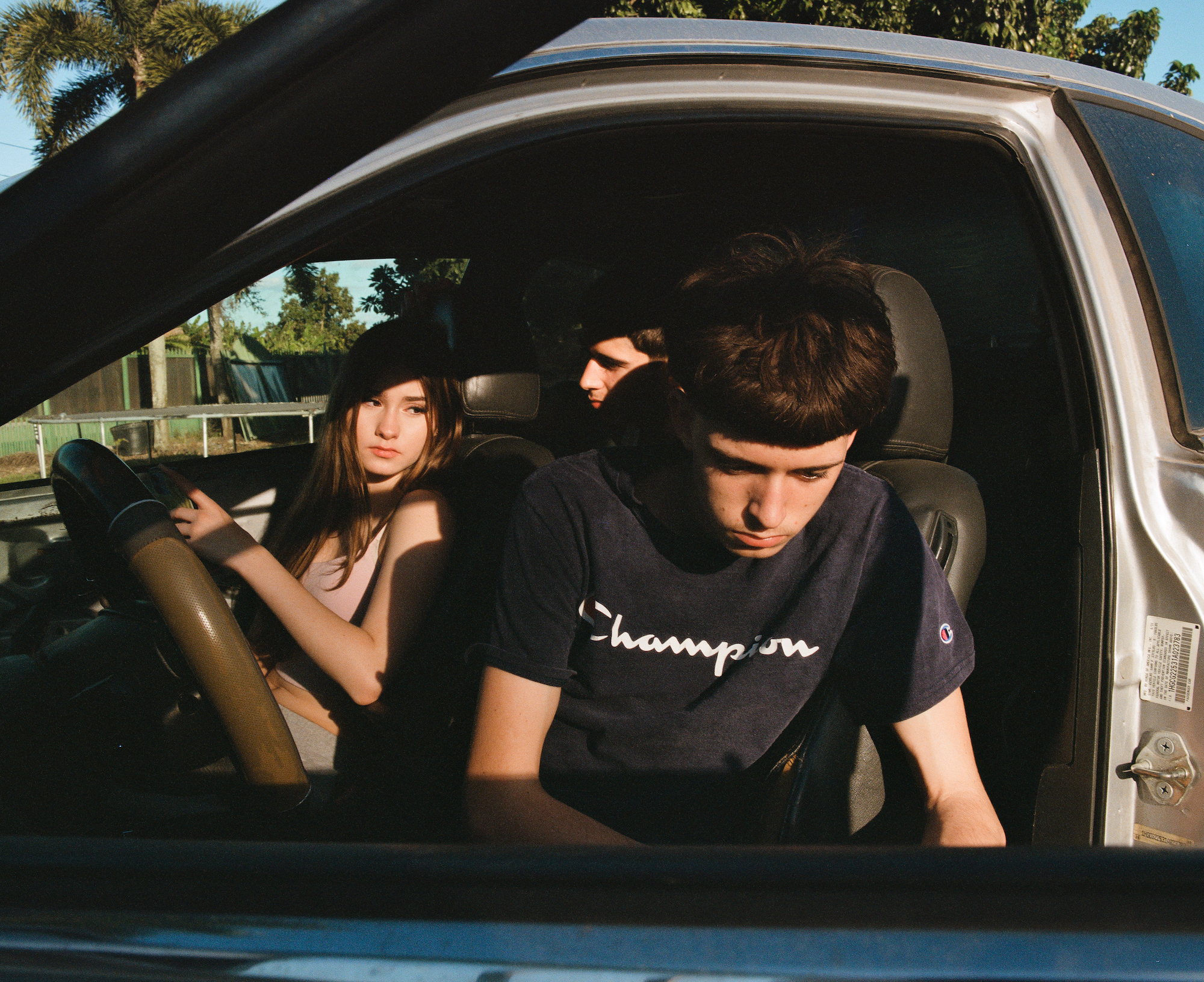 teenagers pictured in the door of a car