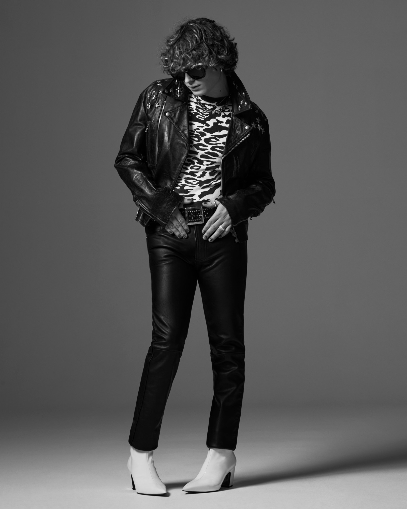 Charlie of Walt Disco wearing leather trousers, a zebra print top and leather jacket with white louboutin boot heels