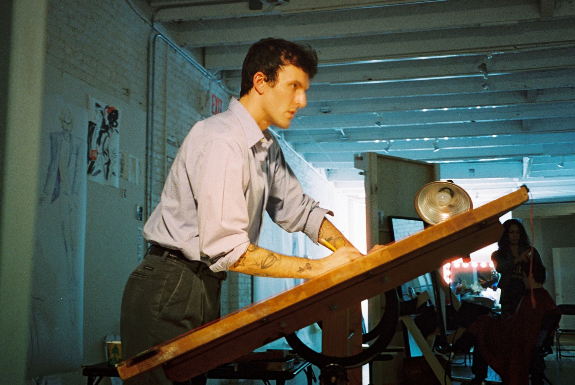 artist drake carr in his studio working on an easel seen in profile